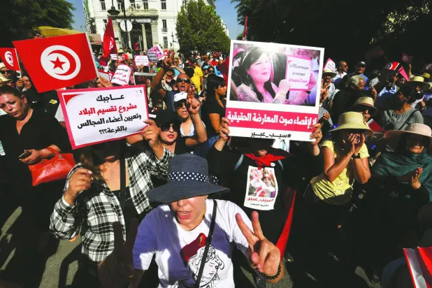 متظاهرون يرفعون صورة عبير موسي في العاصمة التونسية (أ.ف.ب)