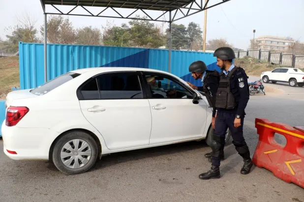 
Pakistani police inspect cars at a checkpoint after a security alert was issued in Islamabad (AP)
