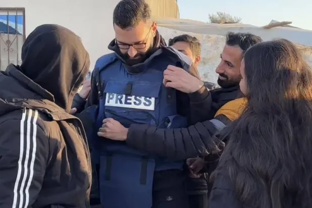 أصدقاء معتز عزايزة ينزعون عنه السترة الواقية من الرصاص (صورة من مقطع فيديو نشره على «إنستغرام»)