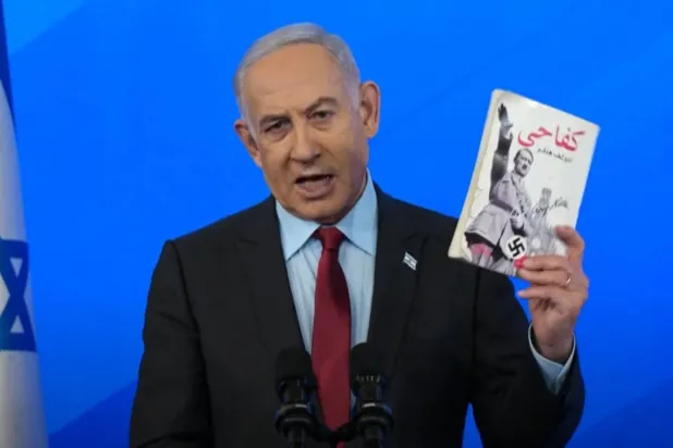 اسرائیلی وزیر اعظم بنجمن نیتن یاہو نے ہفتے کے روز ایک پریس کانفرنس کے دوران کتاب "میری جدوجہد (Mein Kampf)" کا عربی نسخہ (کفاحی) تھامے ہوئے ہیں (روئٹرز)