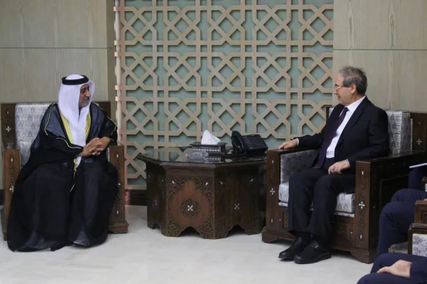 وزير الخارجية السوري فيصل المقداد مع حسن الشحي سفير الإمارات في دمشق (رويترز)