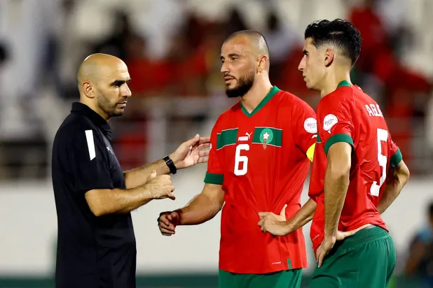 وليد الركراكي يواسي لاعبي المغرب عقب الخروج (رويترز)