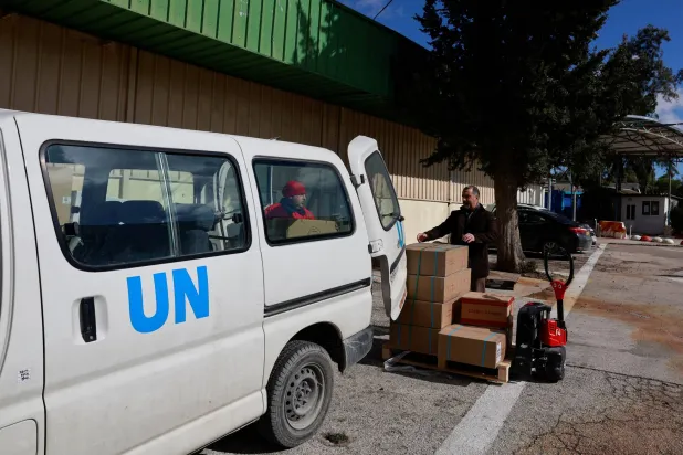 کارکن القدس کے محلے شیخ جراح میں "اونروا" کے دفاتر سے امداد پہنچاتے ہوئے (روئٹرز)