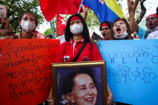 متظاهرة تحمل صورة الزعيمة المنتخبة أونغ سان سو تشي خلال احتجاج ضد النظام العسكري خارج مكتب «الأمم المتحدة» في بانكوك (تايلاند) الخميس (رويترز)