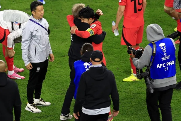 كلينسمان يعانق لاعبي كوريا الجنوبية بعد الفوز الثمين (رويترز)