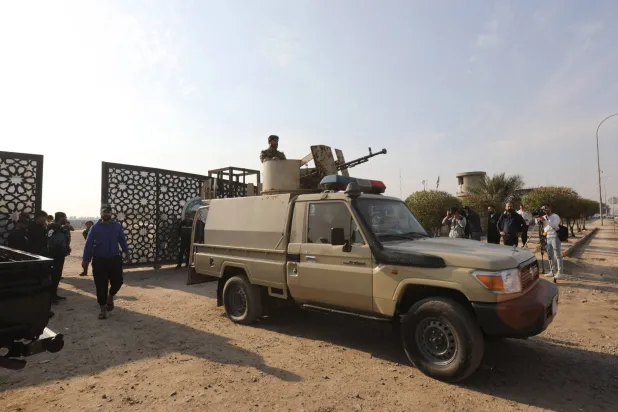 عناصر من «الحشد الشعبي» العراقي بالقرب من البوابة بعد هجوم بطائرة من دون طيار على مقر أمني في بغداد مطلع الشهر الماضي (إ.ب.أ)