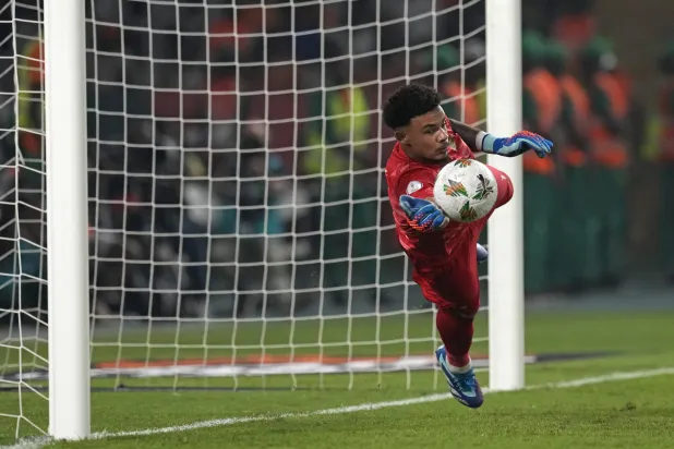 رونوين ويليامز حارس جنوب أفريقيا يصد إحدى ركلات الرأس الأخضر (أ.ب)