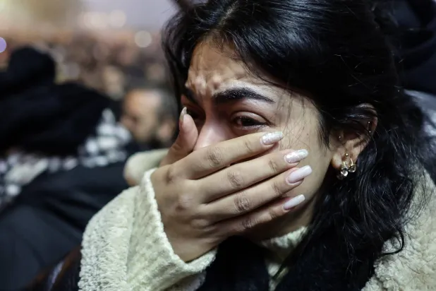 تبكي خلال مسيرة لإحياء الذكرى السنوية للزلزال في هطاي الثلاثاء (إ.ب.أ)