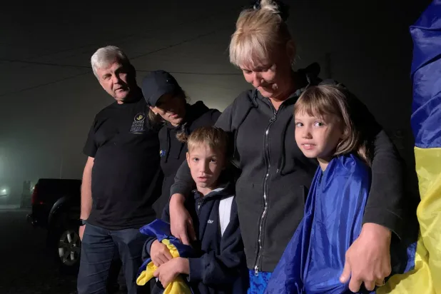 سفيتلانا ريابتسيفا تعانق طفليها أنجلينا (10 سنوات) وأولكسندر (9 سنوات) بعد عودتهما إلى أوكرانيا من الأراضي المحتلة من روسيا عبر الحدود مع بيلاروسيا بمنطقة فولين الأوكرانية 3 سبتمبر 2023 (رويترز)