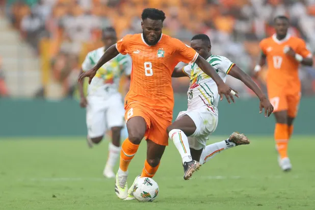كيسي لاعب الأهلي السعودي ومنتخب كوت ديفوار يقود هجمة في مباراة مالي (إ.ب.أ)