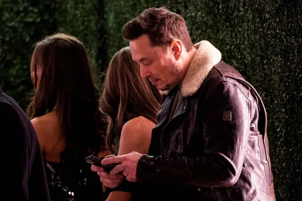 الملياردير الأميركي إيلون ماسك يستخدم هاتفه الجوال (رويترز)