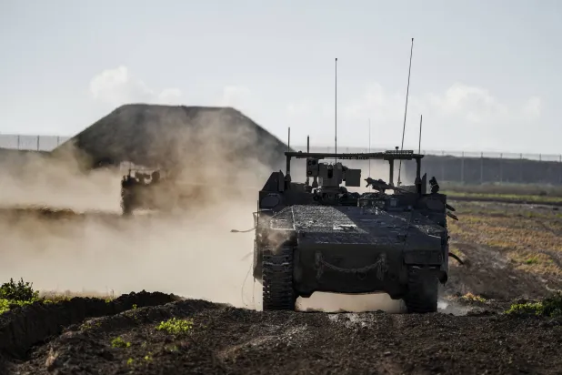 مركبات عسكرية إسرائيلية تظهر من جنوب إسرائيل تعمل بالقرب من قطاع غزة (أ.ب)