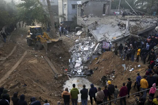 فلسطینی جمعہ کے روز غزہ کی پٹی میں دیر البلح پر اسرائیلی حملے کے مقام پر زندہ بچ جانے والوں اور متاثرین کی تلاش کر رہے ہیں (اے پی)