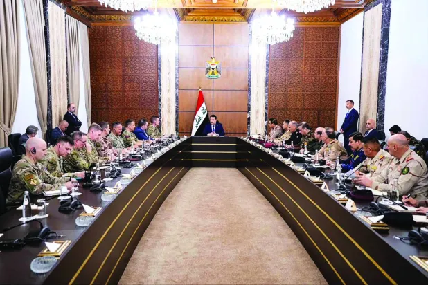 عراقی وزیر اعظم کے میڈیا آفس کی طرف سے شائع کردہ ایک تصویر میں السودانی کو عراقی مسلح افواج اور بین الاقوامی اتحاد کے سینئر حکام سے ملاقات کرتے ہوئے دکھایا گیا ہے (اے ایف پی)