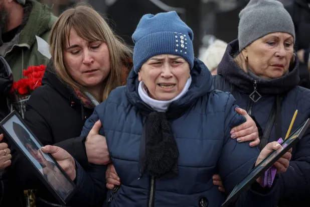أوكرانية تبكي مقتل 5 أفراد من عائلة ابنها بهجوم طائرة مسيّرة خلال جنازتهم في خاركيف الاثنين (رويترز)