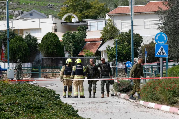 رجال أمن إسرائيليون يتفقدون محيط سقوط صواريخ «حزب الله» في كريات شمونة (أ.ف.ب)