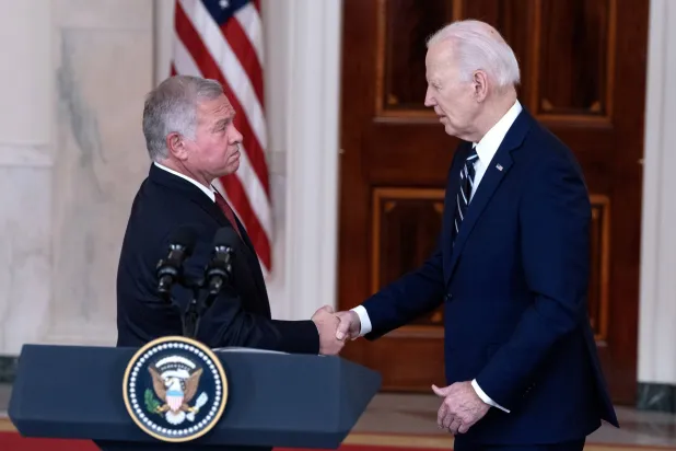 الرئيس الأميركي جو بايدن يصافح الملك عبد الله خلال مؤتمر صحافي عقب اجتماعهما في البيت الأبيض مساء الاثنين (إ.ب.أ)