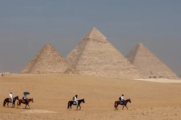 سياح يركبون الخيول أمام الهرم الأكبر بالجيزة على مشارف القاهرة - مصر - 26 أكتوبر 2023 (رويترز)
