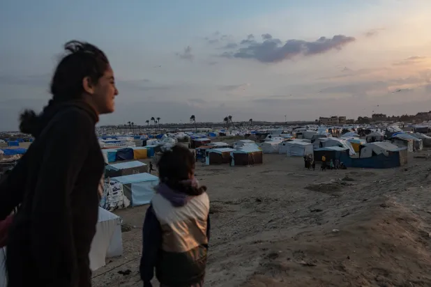 نازحون فلسطينيون على شاطئ البحر قرب مخيم للنازحين في رفح جنوب قطاع غزة (إ.ب.أ)