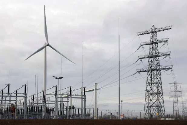 أبراج للطاقة الكهربائية عالية التوتر ومحطة محولات وتوربينات الرياح في نيميغن - هولندا (رويترز)