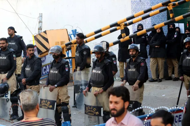 مسؤولو الأمن الباكستانيون يقفون على أهبة الاستعداد بينما يتجمع أنصار «حزب تحريك الإنصاف» الباكستاني للاحتجاج على التزوير المزعوم في الانتخابات العامة في كراتشي بباكستان في 17 فبراير 2024 (إ.ب.أ)