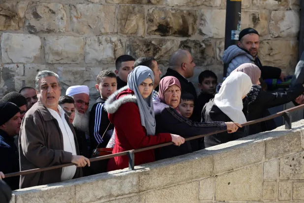 مصلون ينتظرون عند نقطة تفتيش بالقرب من باب الأسباط عند مدخل المسجد الأقصى (أ.ف.ب)