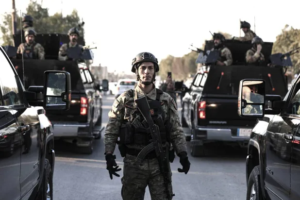 قوات أمن عراقية خلال تشييع قيادي في فصيل مسلح قُتل بغارة أميركية ببغداد الأربعاء 8 فبراير (د.ب.أ)