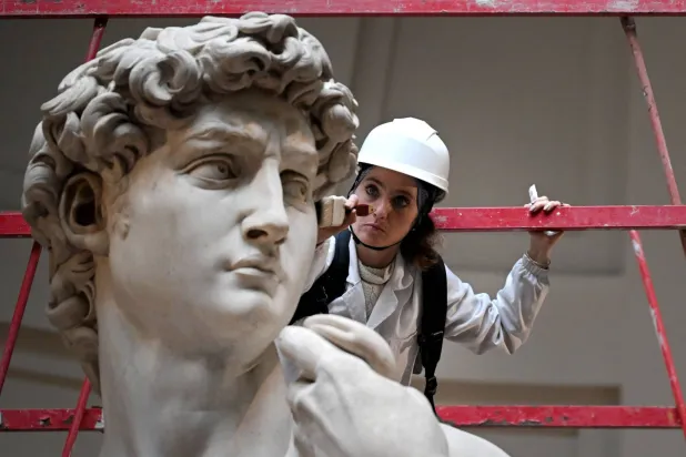 مُرمّمة تنظف تمثال «دافيدي» لميكيلانجيلو في «غاليريا ديل أكاديميا» بفلورنسا (أ.ف.ب)