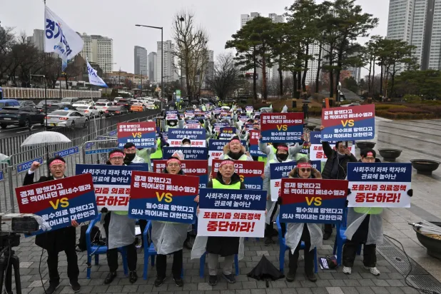 أطباء يحملون لافتات كُتب عليها «أوقفوا السياسة الطبية الشعبوية» خلال مسيرة احتجاجية في سيول (أ.ف.ب)