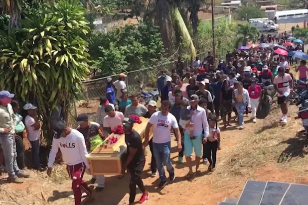 أشخاص يحملون نعش عامل منجم توفي في انهار منجم ذهب غير قانوني في ولاية بوليفار (رويترز)