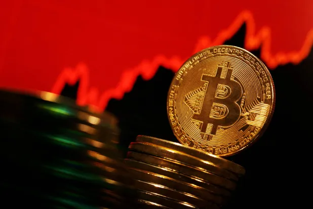 كومة من مجسمات عملة «بتكوين» المشفرة (رويترز)