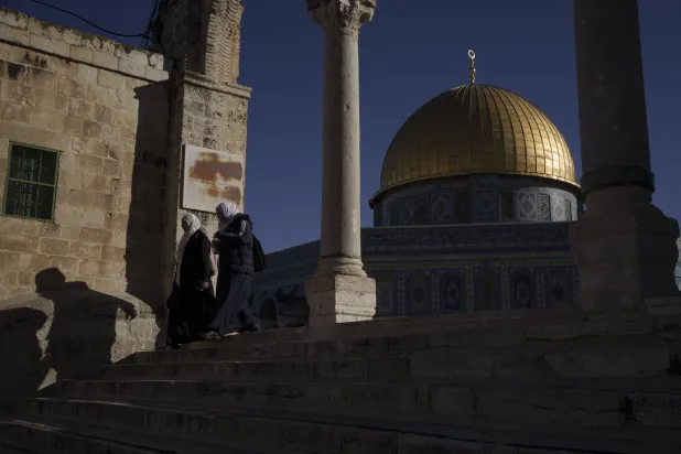 نساء مسلمات يسرن بالقرب من قُبّة الصخرة في مجمع  الأقصى في البلدة القديمة بالقدس، الخميس (أ.ب)