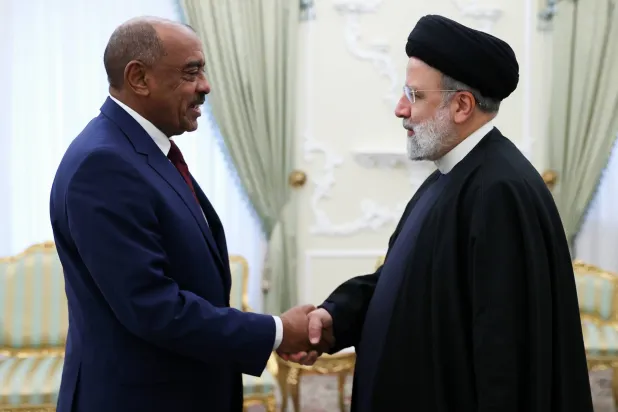 الرئيس الإيراني إبراهيم رئيسي يصافح وزير الخارجية السوداني علي الصادق في طهران الشهر الماضي (الرئاسة الإيرانية)