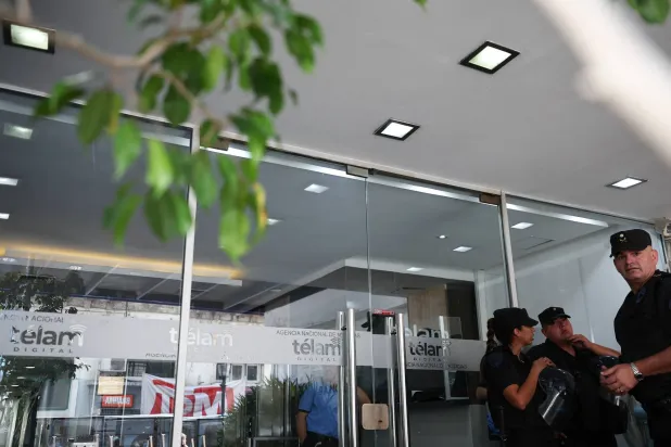 عناصر شرطة يقفون للحراسة في يوم احتجاج عمال وكالة الأنباء الأرجنتينية المملوكة للدولة (تيلام) ضد إغلاق الشركة خارج مبنى «تيلام» في بوينس آيرس بالأرجنتين في 4 مارس 2024 (رويترز)