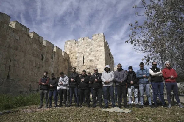 فلسطينيون يصلون الجمعة خارج أسوار البلدة القديمة في القدس بعد أن منعت الشرطة الإسرائيلية دخولهم إلى المسجد مستهل الشهر الحالي (أ.ب)