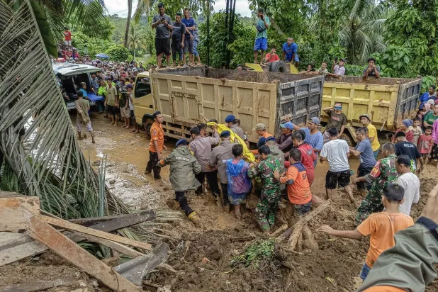 صورة نشرها المجلس الوطني لإدارة الكوارث تظهر رجال الإنقاذ وهم يقومون بإجلاء جثة أحد ضحايا الانهيار الأرضي في بادانج باريامان في مقاطعة سومطرة الغربية في إندونيسيا (إ.ب.أ)