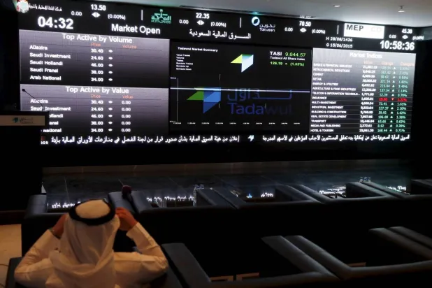مستثمر يتابع تحركات أسعار الأسهم على شاشة «تداول» السعودية (رويترز)