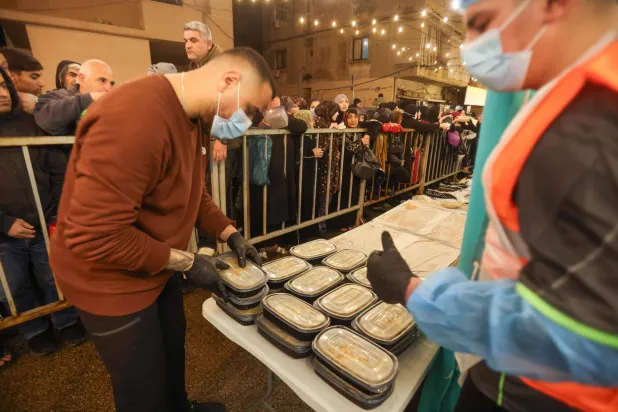 متطوعون يوزعون وجبات سحور رمضانية مجانية في بيروت في أول أيام رمضان لهذا العام (أ.ف.ب)