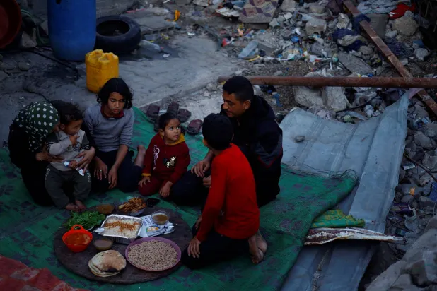 فلسطينيون يستعدون للإفطار وسط أنقاض منزلهم المدمر خلال شهر رمضان (رويترز)