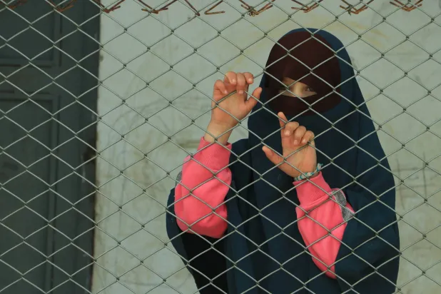 طفلة من خلف سياج شائك في مخيم الهول (الشرق الأوسط)