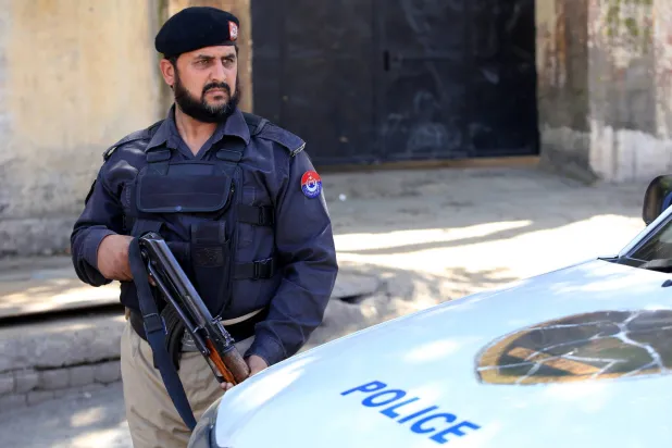 مسؤول أمني باكستاني يقف حارساً عند نقطة تفتيش في بيشاور عاصمة مقاطعة خيبر بخوا بباكستان في 18 مارس 2024 وقالت حكومة «طالبان» إن طائرات مقاتلة باكستانية قصفت قرى أفغانية عدة (إ.ب.أ)