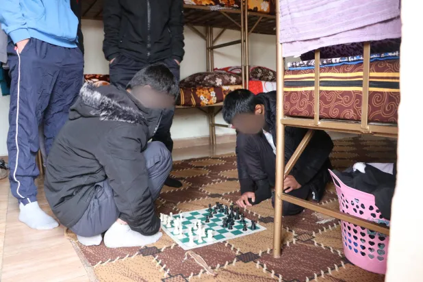 مهجع الشبان في مركز هوري وبدا اثنان يلعبان الشطرنج (الشرق الأوسط)