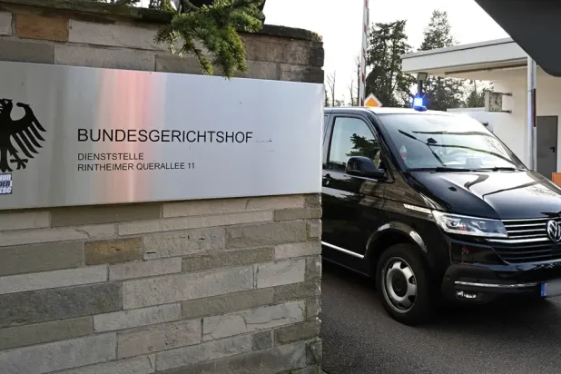 Police vehicles leave the Federal Public Prosecutor's Office at the Federal Court of Justice in Karlsruhe, Germany (AP)