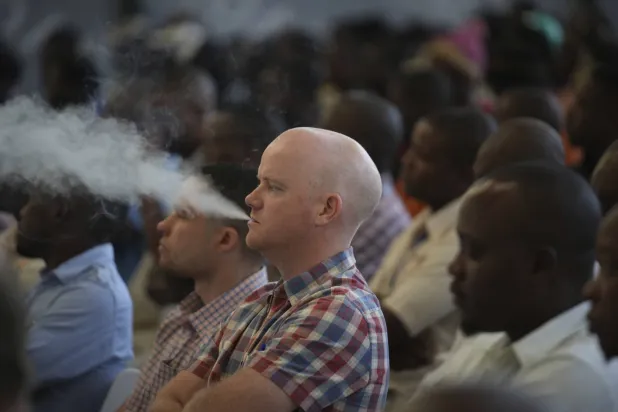 رجل يدخن السجائر الإلكترونية خلال افتتاح موسم بيع التبغ في زيمبابوي (أ.ب)