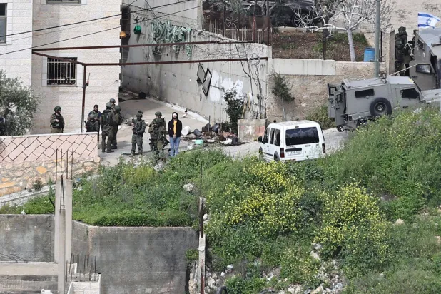 قوات إسرائيلية تحتجز فلسطينياً في الضفة الغربية (أ.ف.ب)