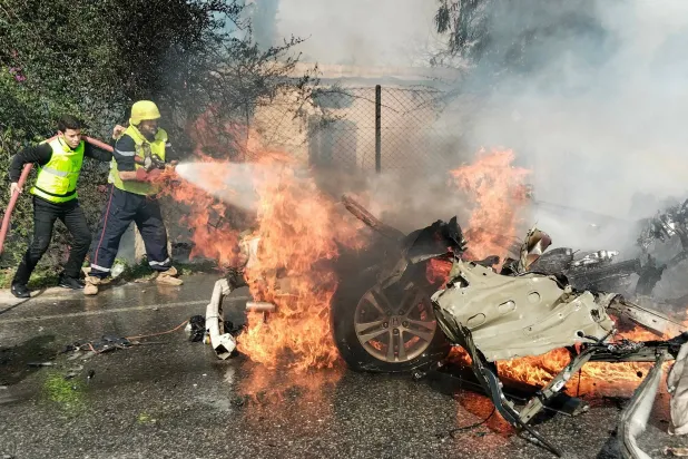 Firefighters douse a burning car after it was hit in a reported Israeli drone attack in Lebanon's southern area of Naqoura near the border with Israel on March 13, 2024, amid ongoing cross-border tensions as fighting continues between Israel and Palestinian Hamas militants in the Gaza Strip. (Photo by AFP)