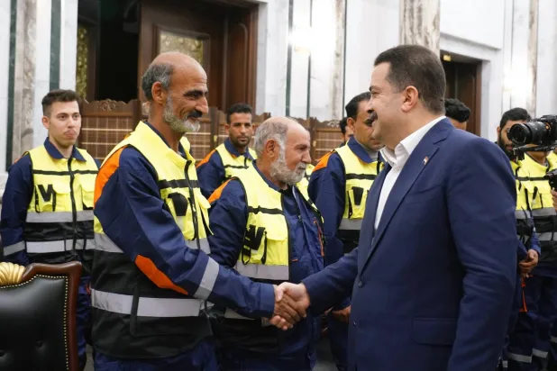 السوداني خلال لقائه عمال نظافة في بغداد خلال مأدبة رمضانية (إعلام حكومي)