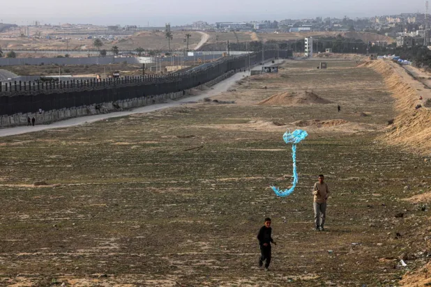 Refah'ta Mısır sınırı yakınlarında uçurtma uçuran yerinden edilmiş Filistinli bir çocuk (AFP)