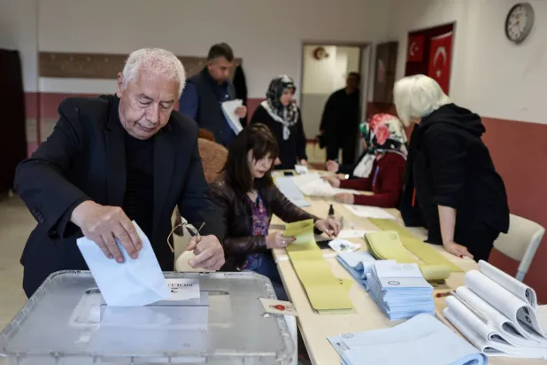 شخص يصوّت في الانتخابات المحلية بمركز اقتراع في إسطنبول بتركيا (إ.ب.أ)
