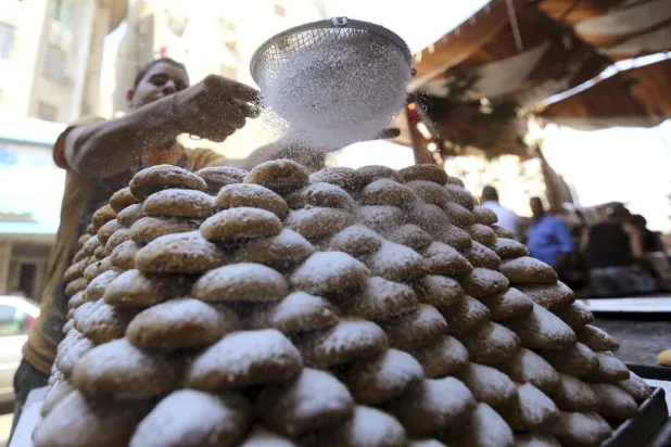 عامل يرش حبات السكر على الكعك في أحد المخابز بالقاهرة (أرشيفية - رويترز)